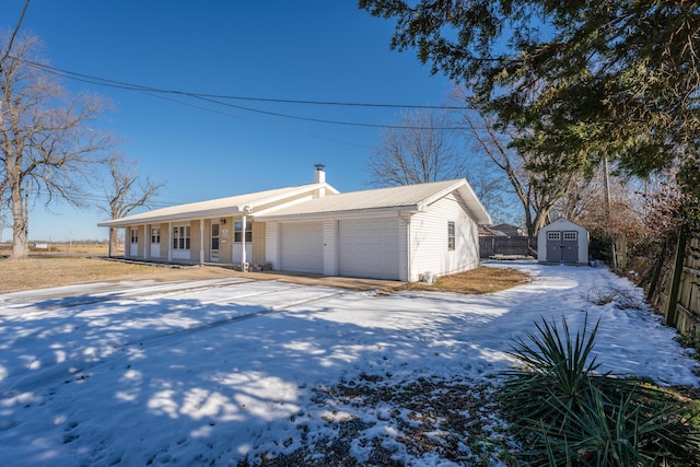 ranch-style house with a porch, a garage, and a shed