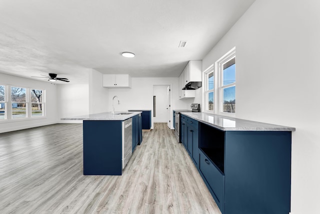 kitchen with sink, blue cabinetry, white cabinets, and stainless steel appliances