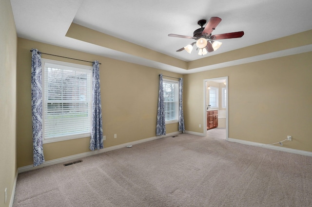 empty room featuring ceiling fan, plenty of natural light, and light colored carpet