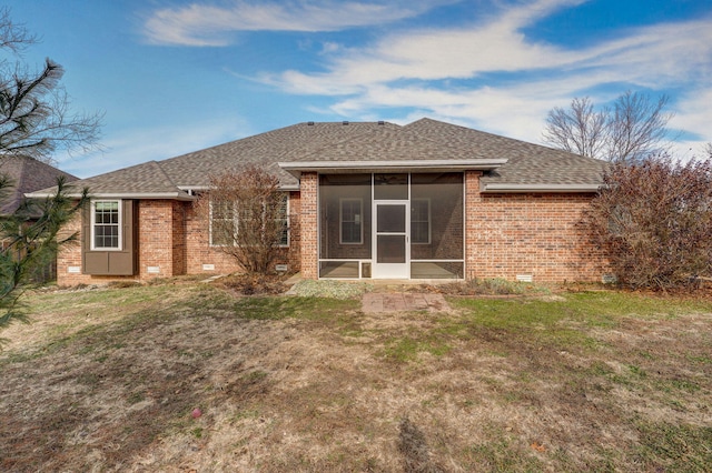 back of property with a sunroom and a lawn