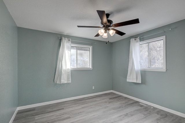 empty room with ceiling fan and light wood-type flooring