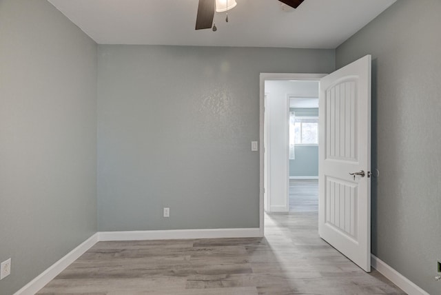 spare room with ceiling fan and light wood-type flooring