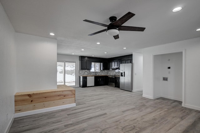 kitchen featuring appliances with stainless steel finishes, tasteful backsplash, sink, ceiling fan, and light hardwood / wood-style flooring