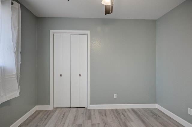 unfurnished bedroom with ceiling fan, a closet, and light hardwood / wood-style flooring