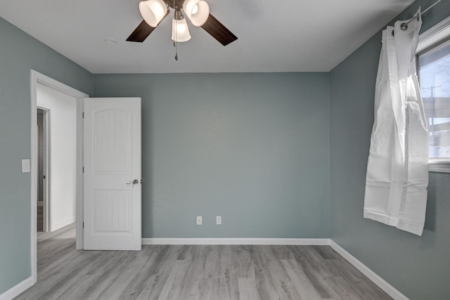 empty room with ceiling fan and light hardwood / wood-style floors