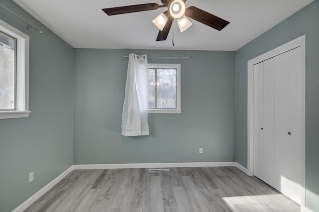 unfurnished bedroom featuring ceiling fan, a closet, and light hardwood / wood-style flooring