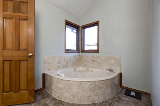 bathroom with vaulted ceiling, tile patterned floors, and a bathtub