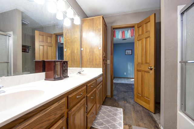 bathroom with vanity, bath / shower combo with glass door, and hardwood / wood-style floors