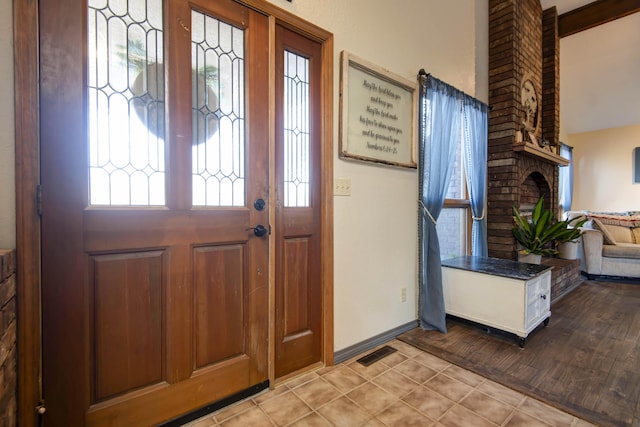 tiled foyer entrance featuring a fireplace