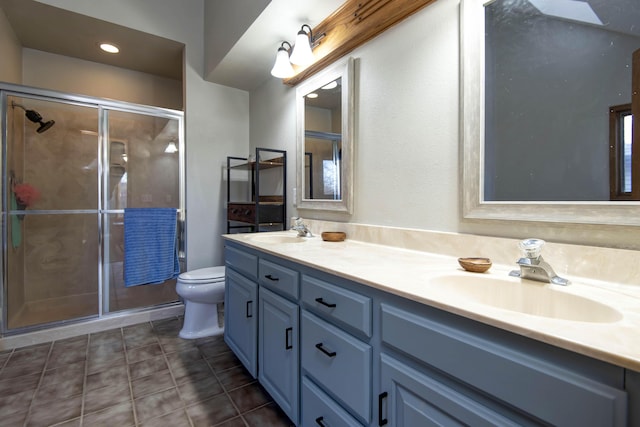 bathroom with vanity, toilet, tile patterned floors, and a shower with door