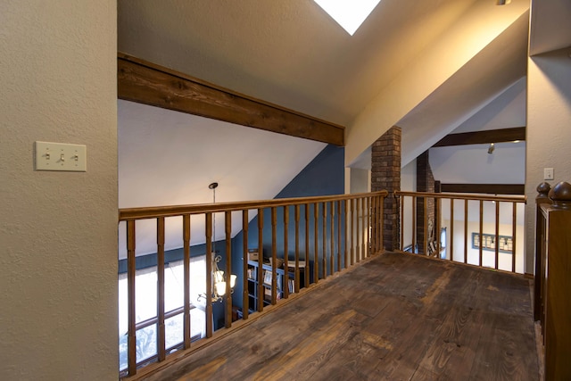 hall featuring wood-type flooring and vaulted ceiling with beams