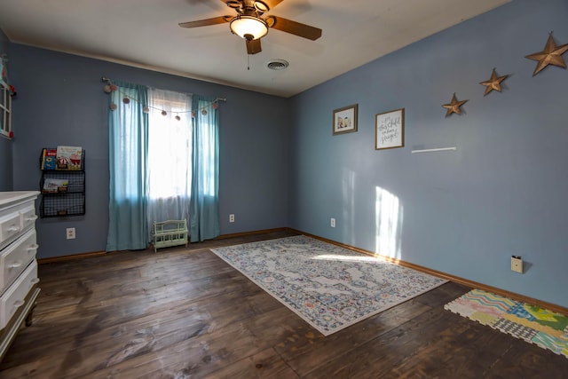 unfurnished room with ceiling fan and dark hardwood / wood-style flooring