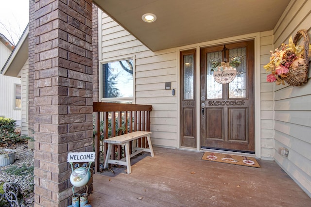 view of exterior entry featuring covered porch