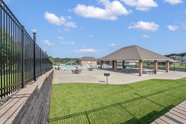 surrounding community featuring a swimming pool, a gazebo, a lawn, and fence