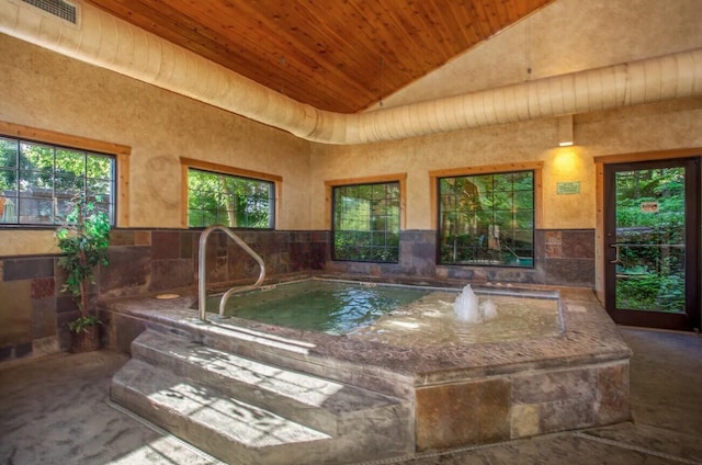 view of swimming pool featuring an indoor hot tub