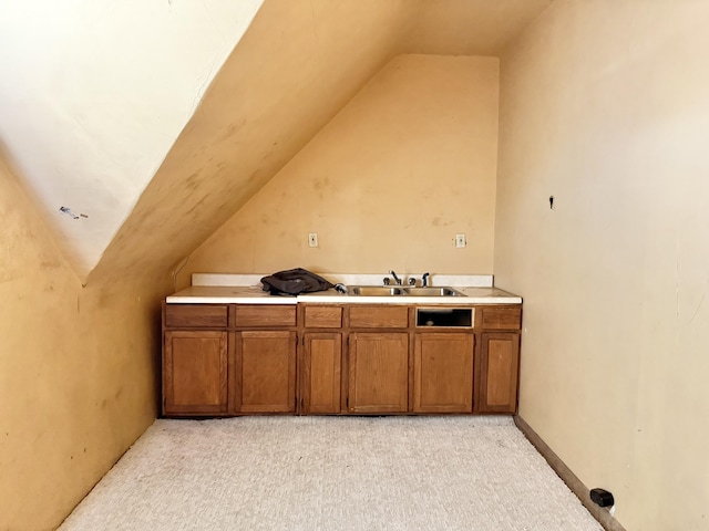 interior space with light carpet, lofted ceiling, and sink