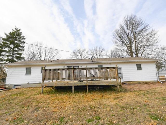 back of property with a yard and a wooden deck