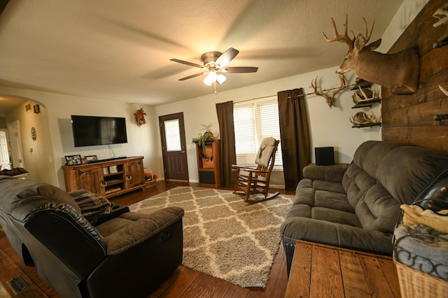 living room featuring ceiling fan and dark hardwood / wood-style flooring