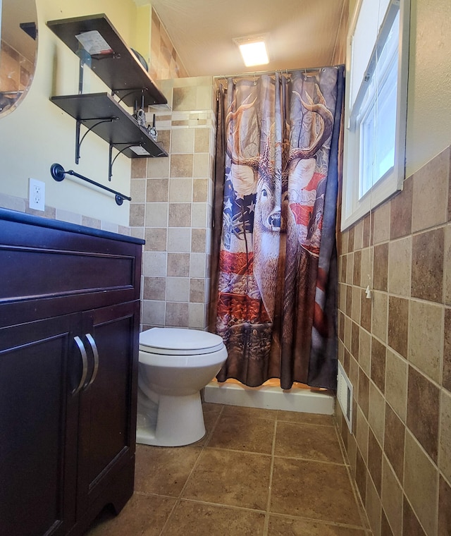 bathroom featuring toilet, tile walls, a shower with shower curtain, and tile patterned flooring