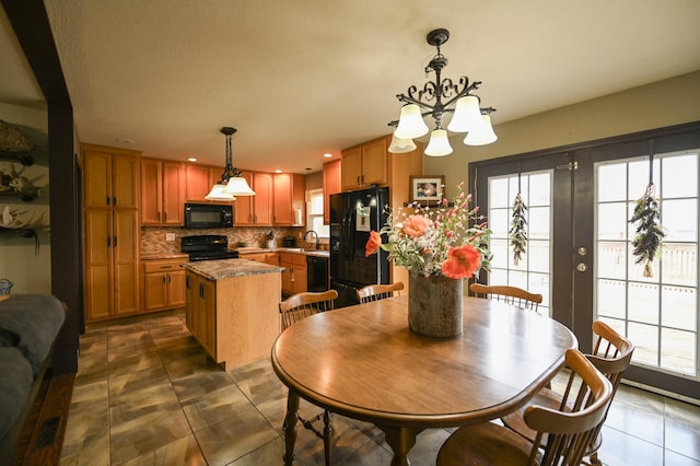 dining area featuring dark tile patterned flooring, sink, a wealth of natural light, and french doors