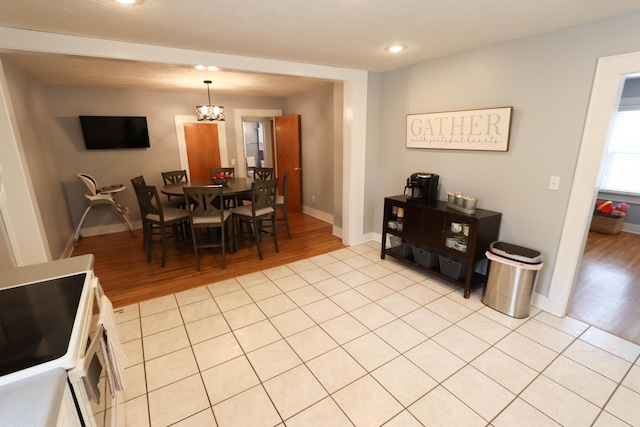 dining space with light tile patterned floors and a chandelier