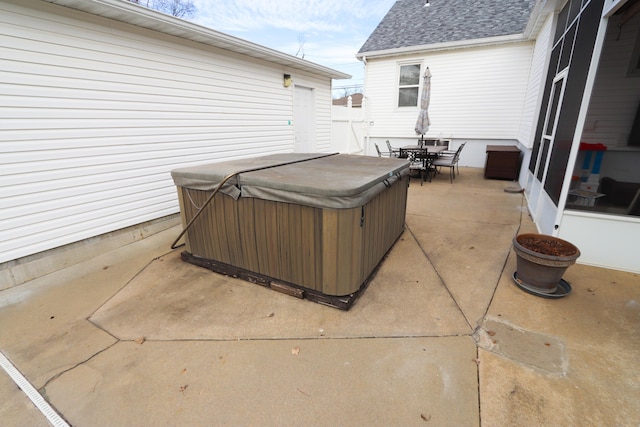 view of patio / terrace featuring a hot tub and a sunroom