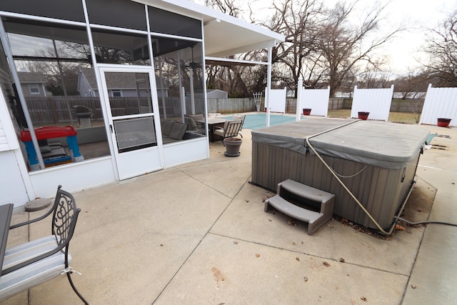 view of patio with a hot tub and a sunroom