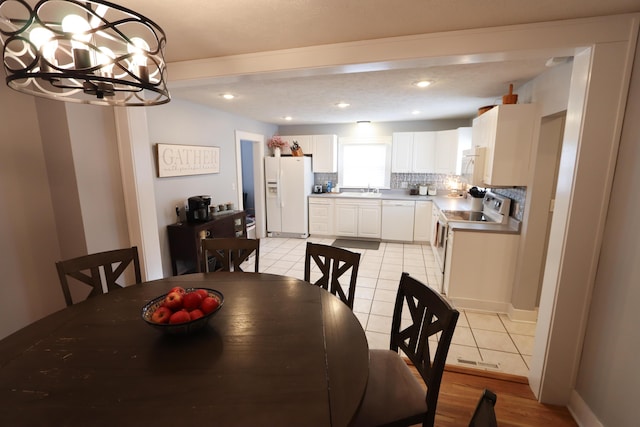 dining space featuring light tile patterned floors, a notable chandelier, and sink