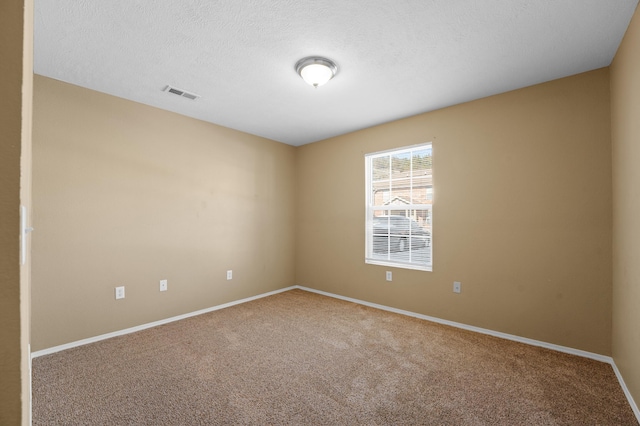 carpeted spare room featuring a textured ceiling