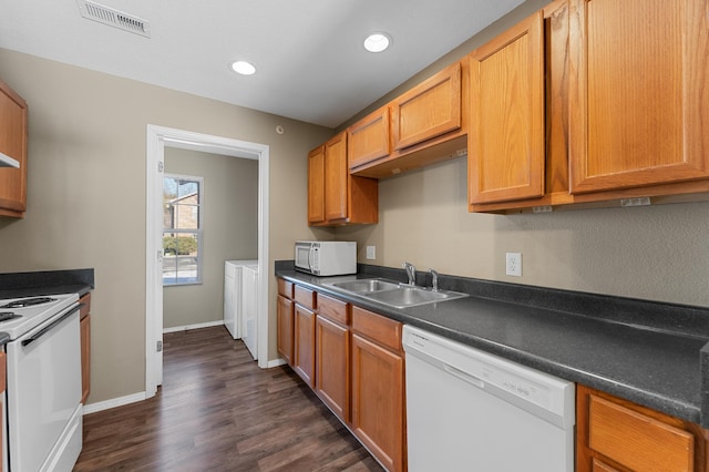 kitchen with sink, white appliances, washer and clothes dryer, and dark hardwood / wood-style flooring