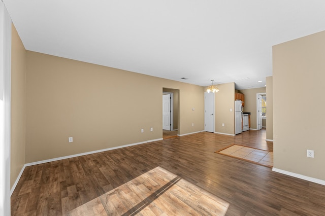 unfurnished room with hardwood / wood-style floors and a chandelier