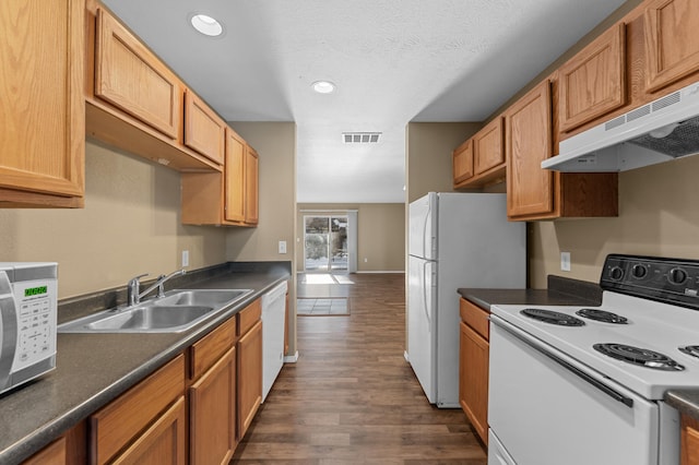 kitchen with dark wood-type flooring, sink, white appliances, and a textured ceiling