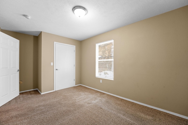 unfurnished bedroom featuring carpet, a closet, and a textured ceiling