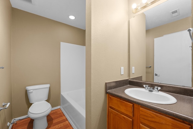 bathroom featuring toilet, vanity, and hardwood / wood-style flooring