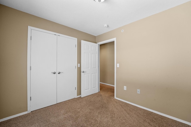 unfurnished bedroom featuring carpet and a closet