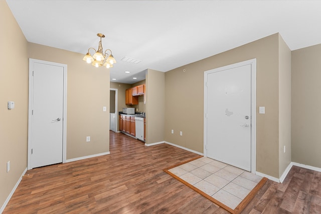 interior space with dishwasher, an inviting chandelier, and light wood-type flooring