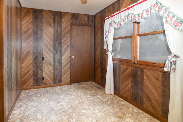 entryway featuring wooden walls and a textured ceiling