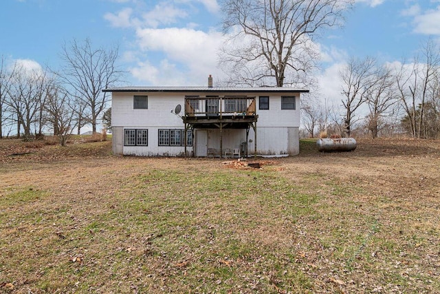 back of house featuring a lawn and a wooden deck