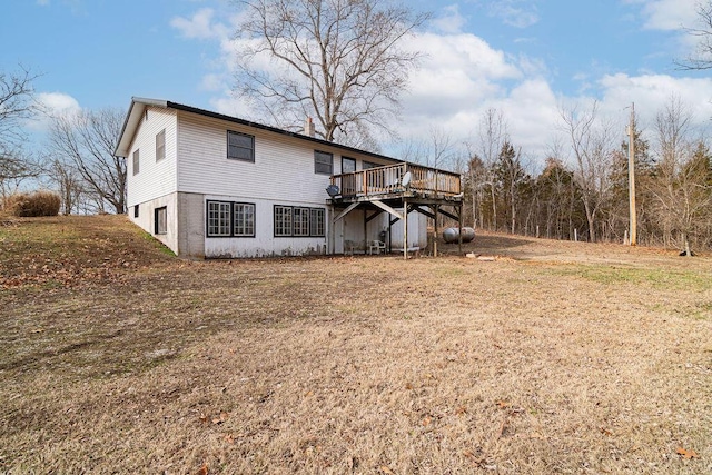 back of property with a wooden deck and a lawn