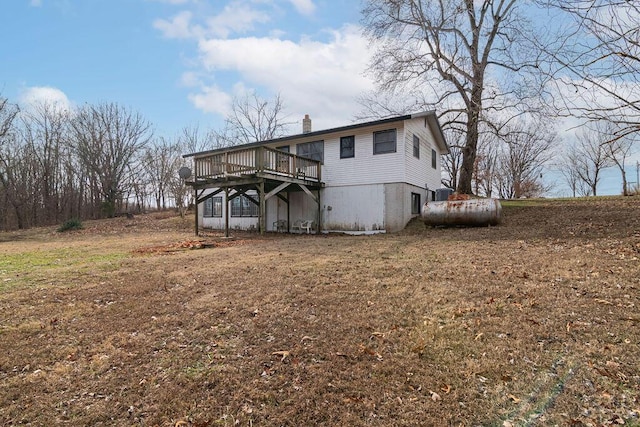 back of property with a wooden deck and a yard