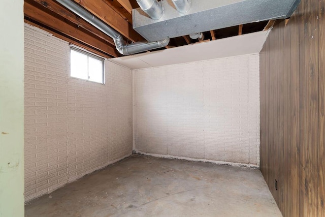 basement featuring brick wall and wood walls