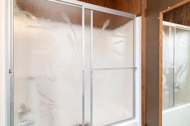 bathroom featuring bath / shower combo with glass door