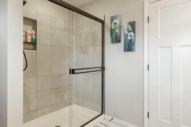 bathroom featuring a shower with door