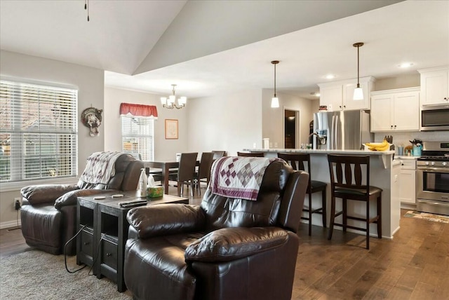 living room with sink, dark hardwood / wood-style flooring, lofted ceiling, and a chandelier