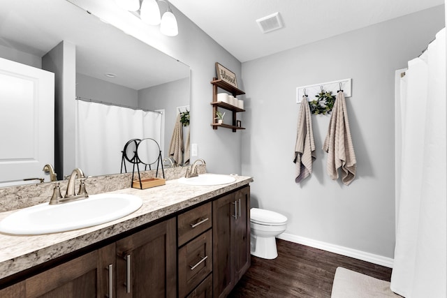 bathroom featuring vanity, hardwood / wood-style flooring, and toilet