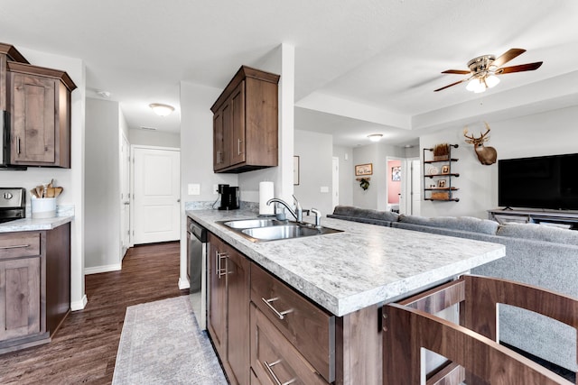 kitchen featuring dark wood-type flooring, sink, ceiling fan, stainless steel dishwasher, and dark brown cabinets