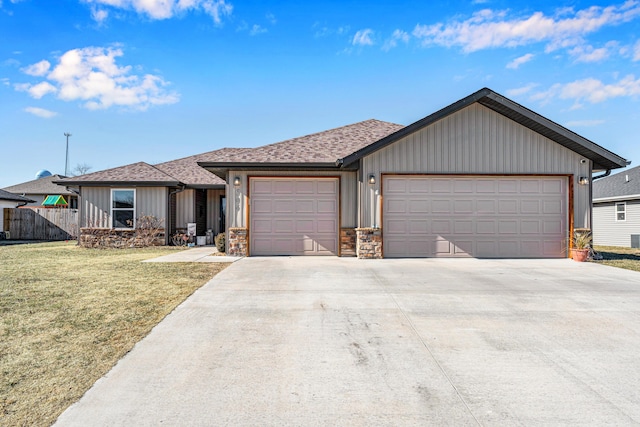 ranch-style home with a garage and a front lawn