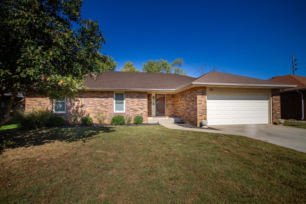 ranch-style home featuring a front yard and a garage