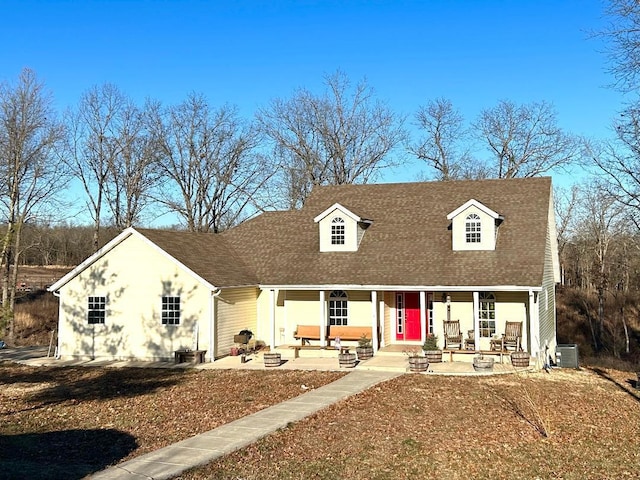 cape cod-style house with a patio area, a fire pit, a porch, and central air condition unit