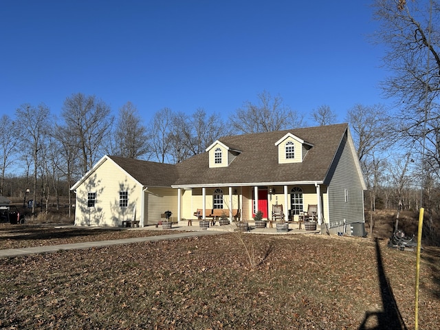 cape cod home with a patio, a porch, and central AC